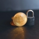 a bit coin sitting on top of a padlock